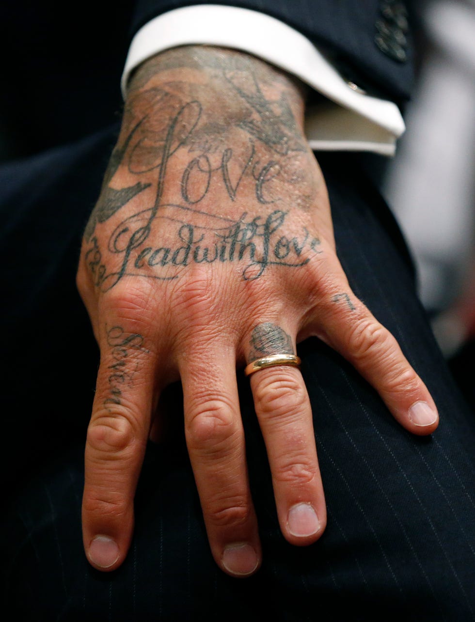 Close-up of David Beckham’s hand lettering and finger tattoos