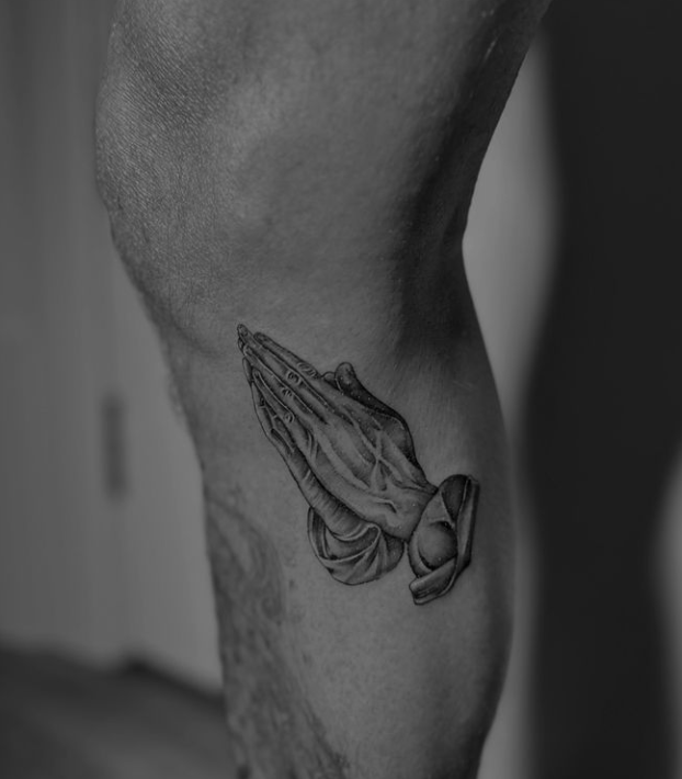 David Beckham’s black-and-gray praying hands tattoo below the knee