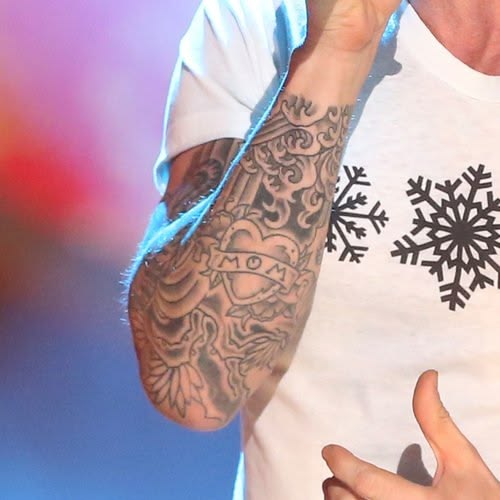 Close view of Adam Levine's heart tattoo with Mom lettering on his forearm