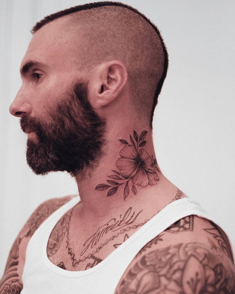 Adam Levine's fine-line flower tattoo on the side of his neck