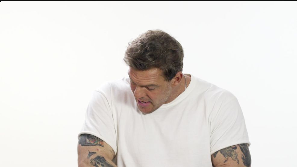 Alan Ritchson showing tattoos across both arms during GQ Tattoo Tour.