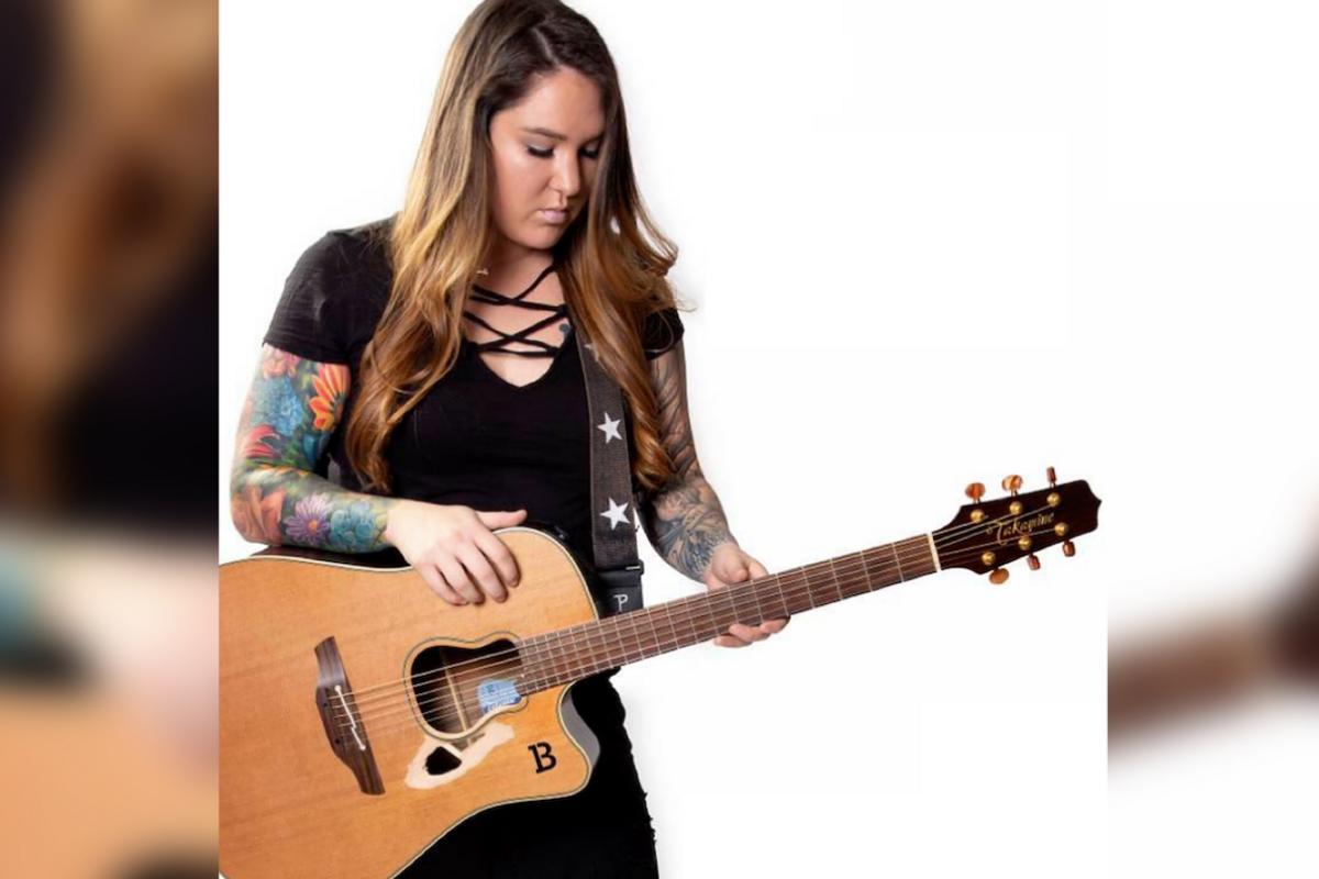 Allie Colleen floral sleeve tattoos while playing guitar