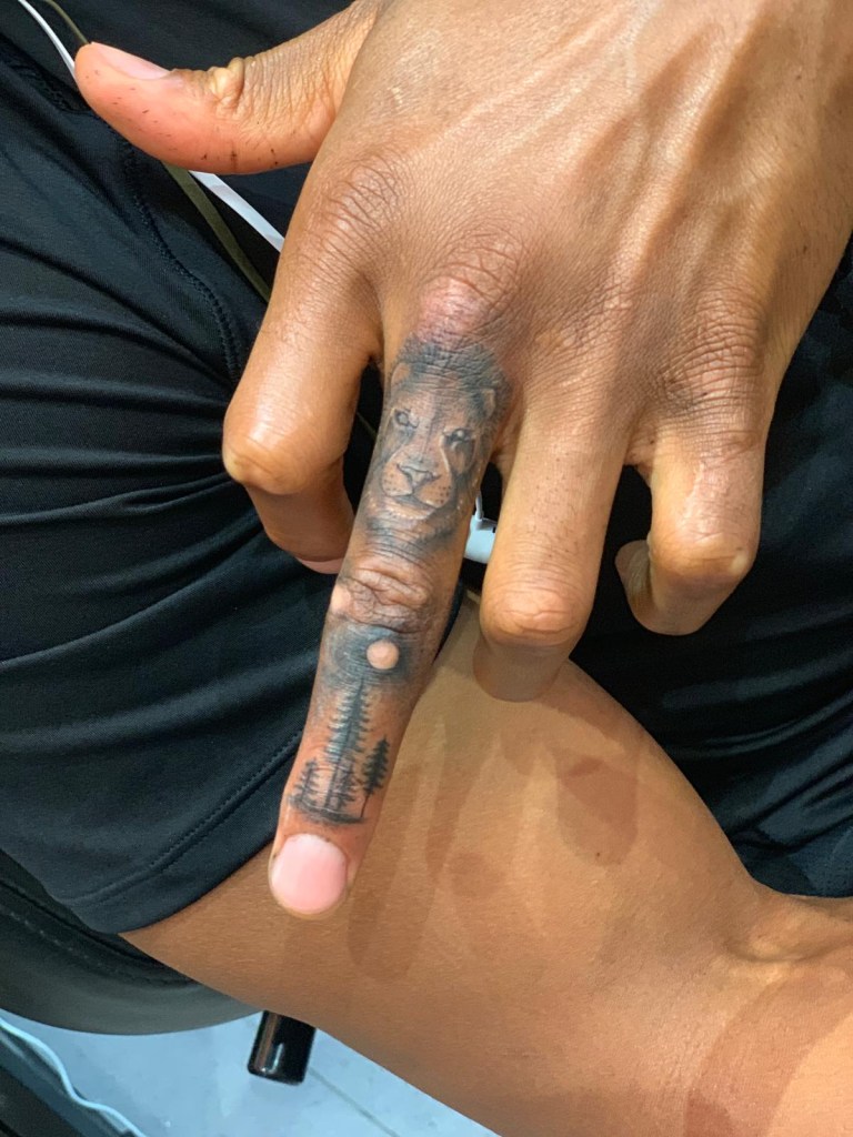 Anthony Joshua lion and forest tattoo on his middle finger