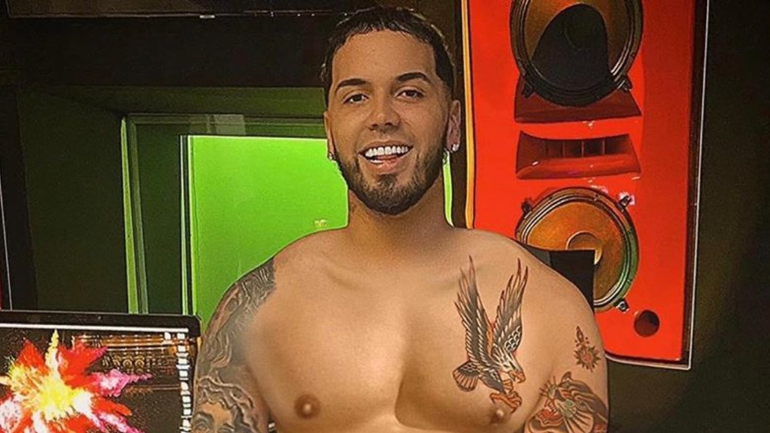 Anuel AA showing the eagle and other chest tattoos.