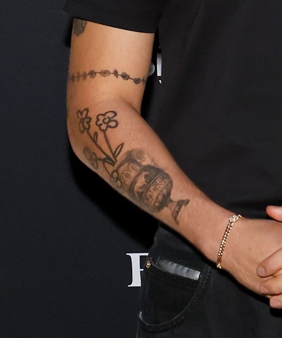 Bad Bunny tattoos: Bad Bunny vase and cartoon flower forearm tattoos