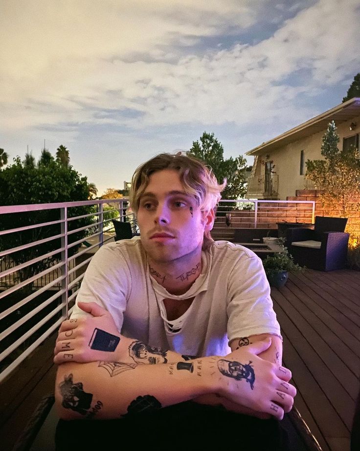 Luke Hemmings showing tattoos on his balcony portrait