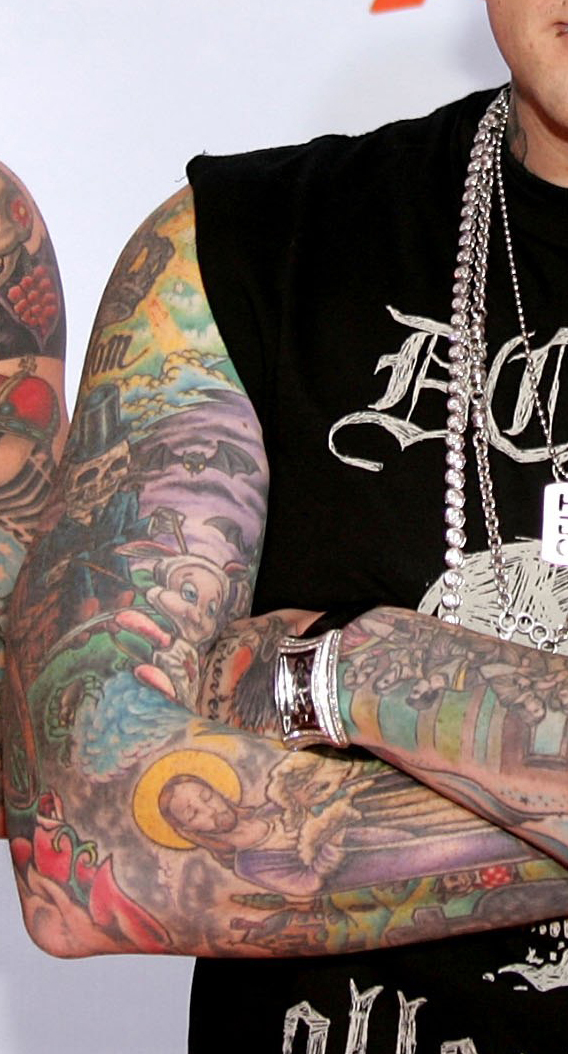Benji Madden colorful sleeve tattoos with arms crossed