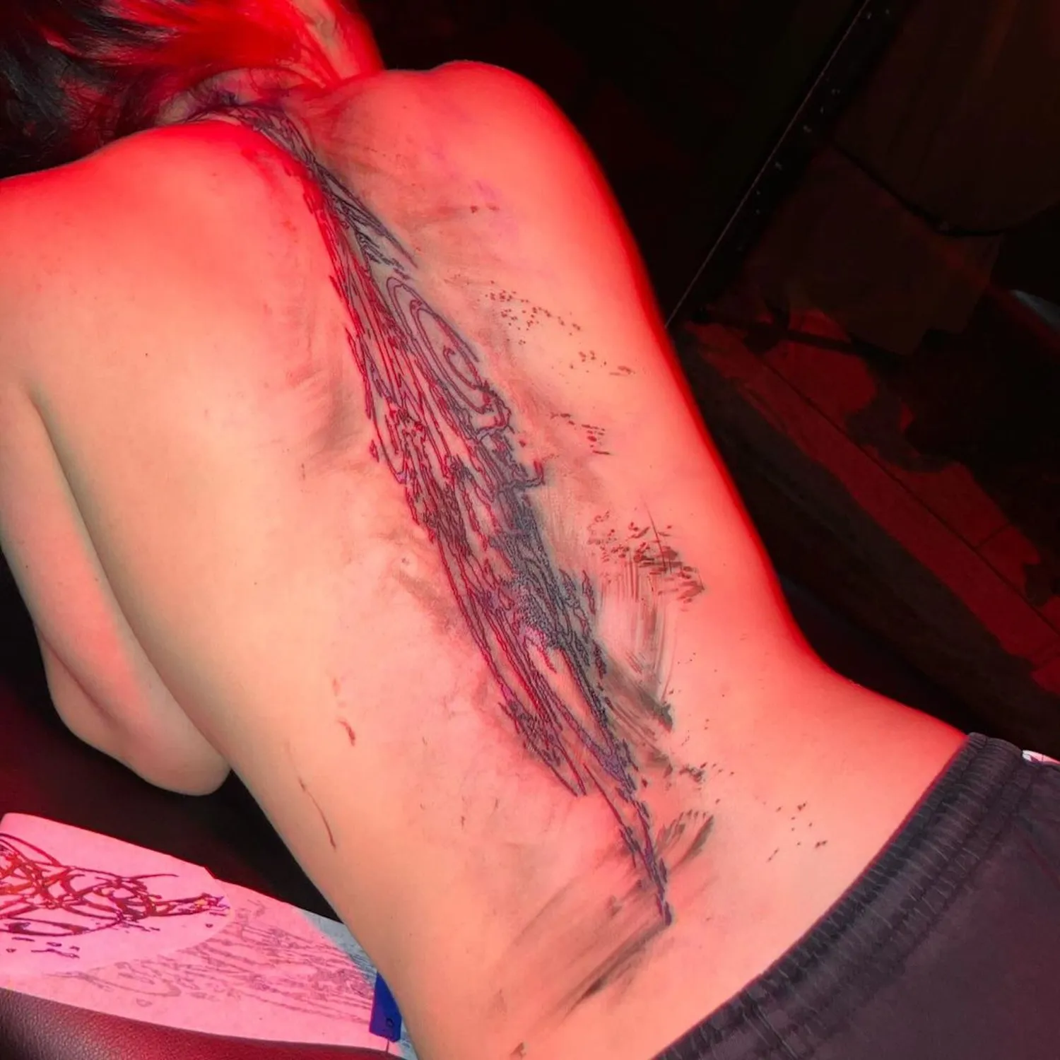 Billie Eilish abstract back tattoo running along her spine
