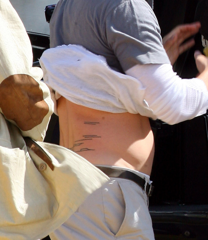 Brad Pitt minimalist rib line tattoo