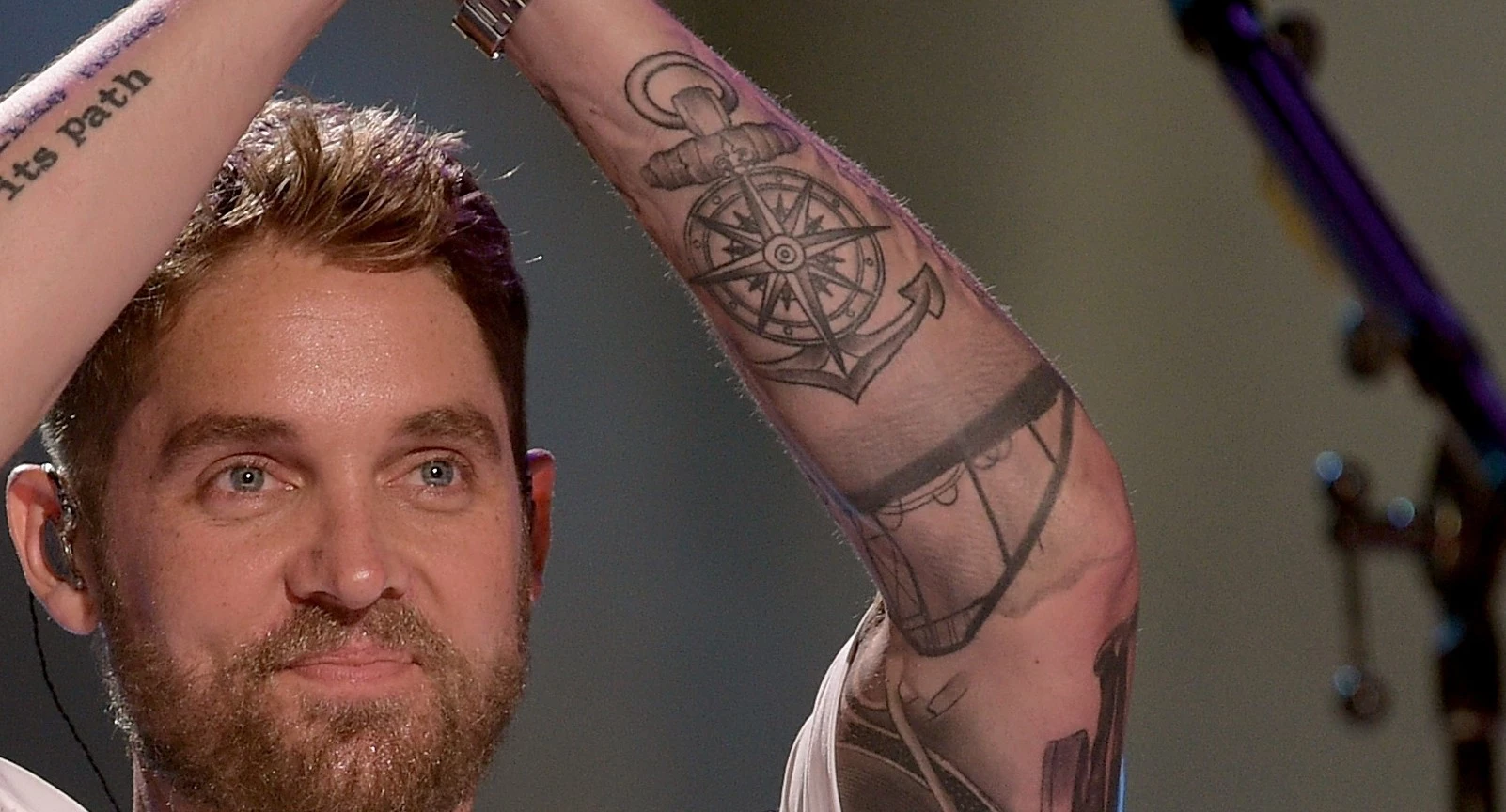 Brett Young compass and anchor tattoos on his tattooed arm