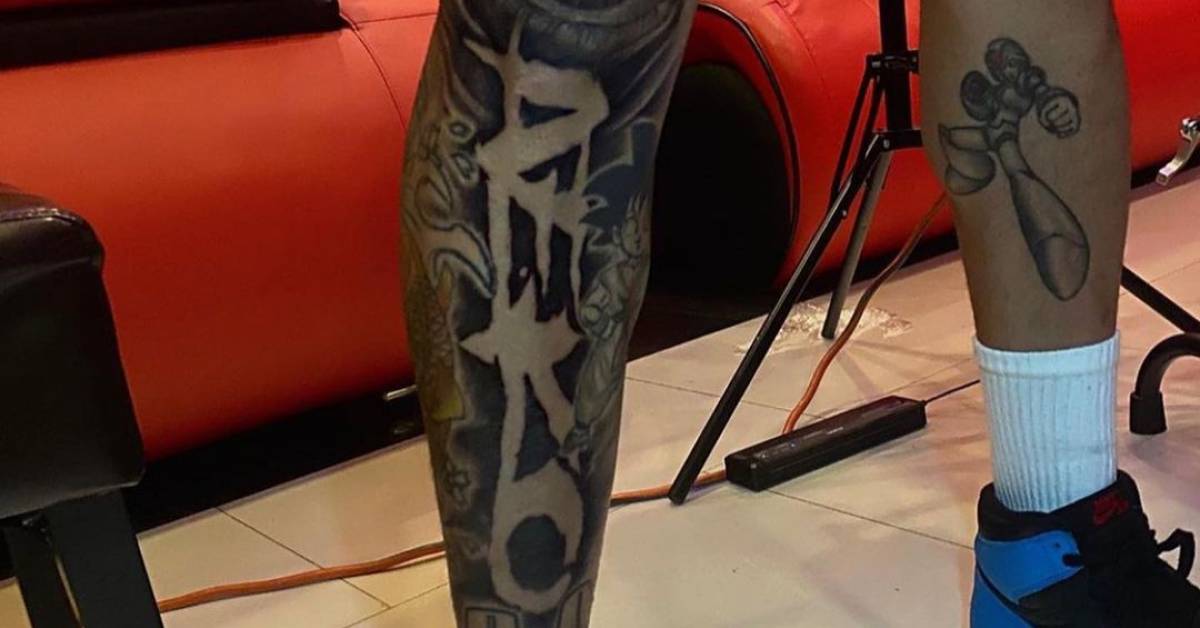 Chris Brown's Aeko lettering and character tattoo on the other shin