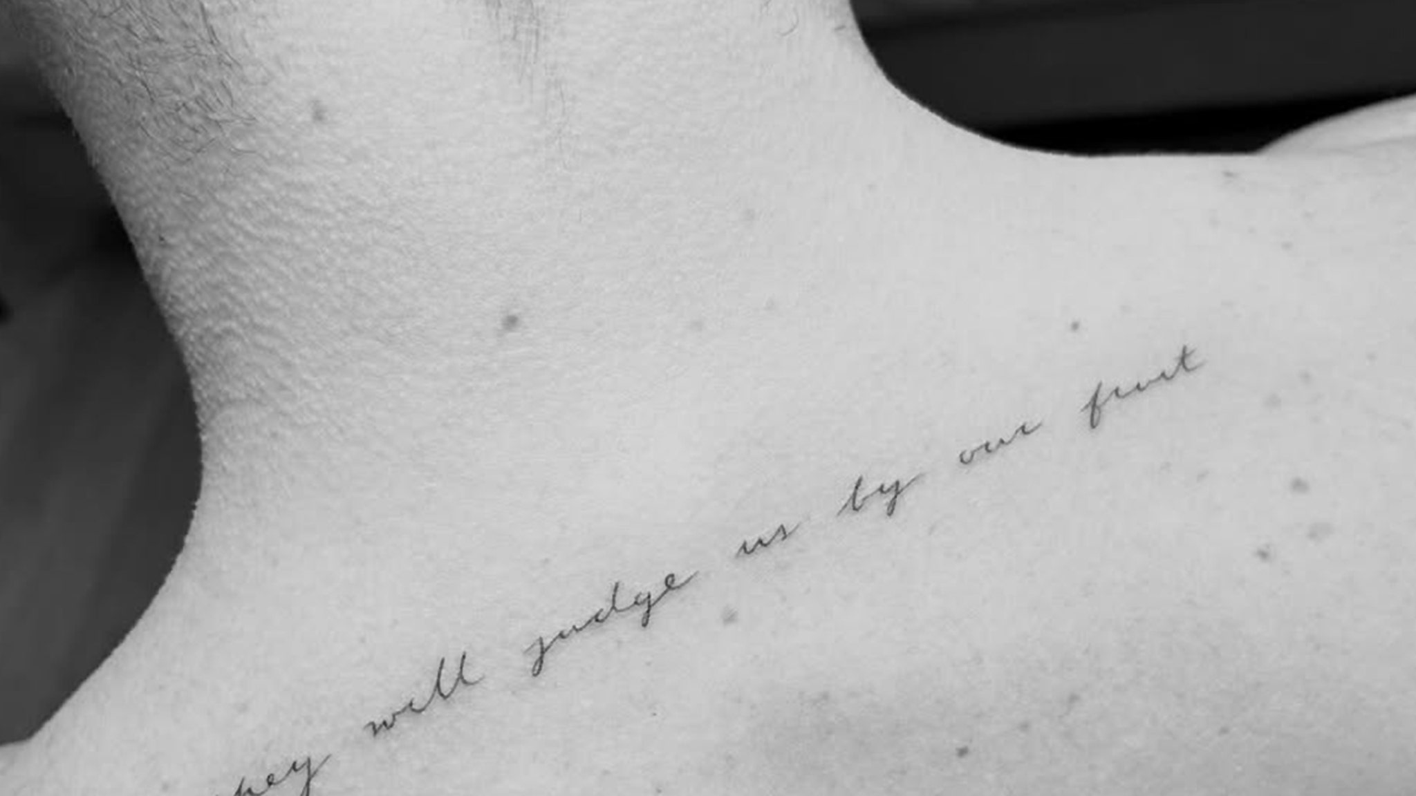 Chase Stokes upper-back scripture tattoo close-up