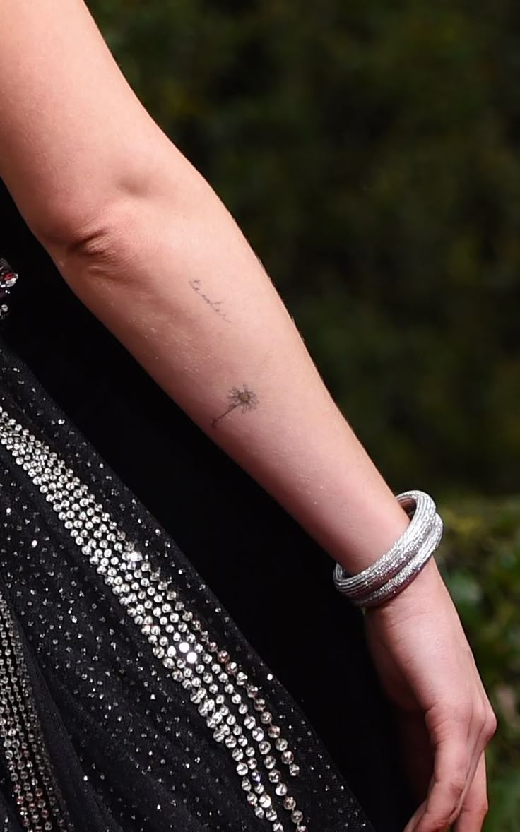 Dakota Johnson delicate flower and forearm tattoo