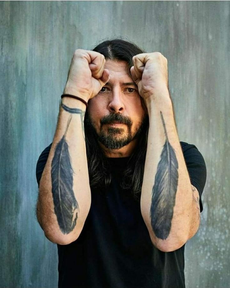 Dave Grohl matching feather tattoos on his forearms
