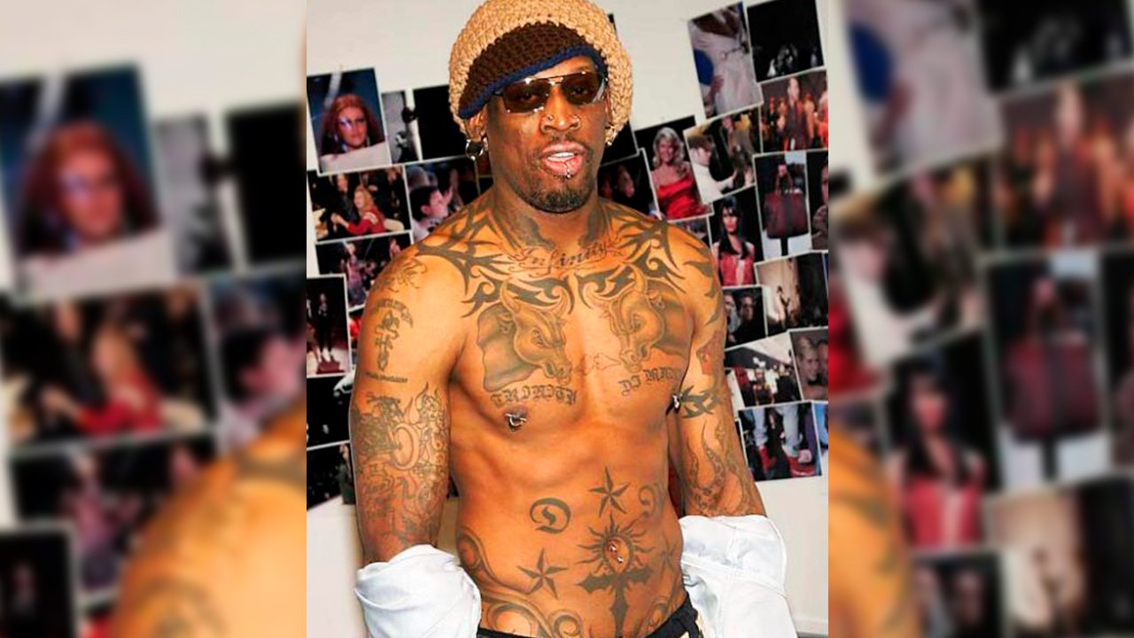 Dennis Rodman showing motorcycle and cross tattoos on his right arm