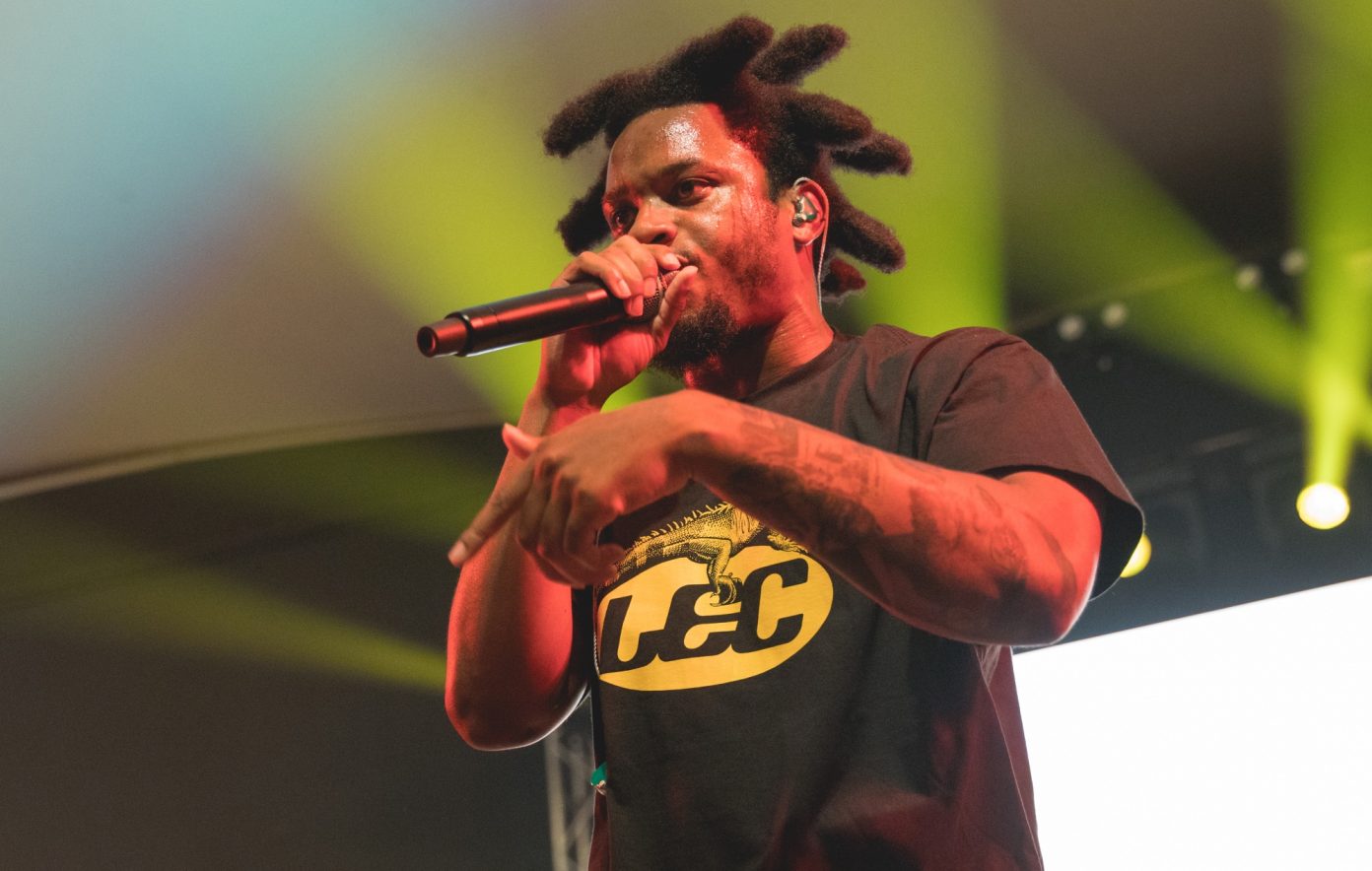Denzel Curry forearm tattoos on stage