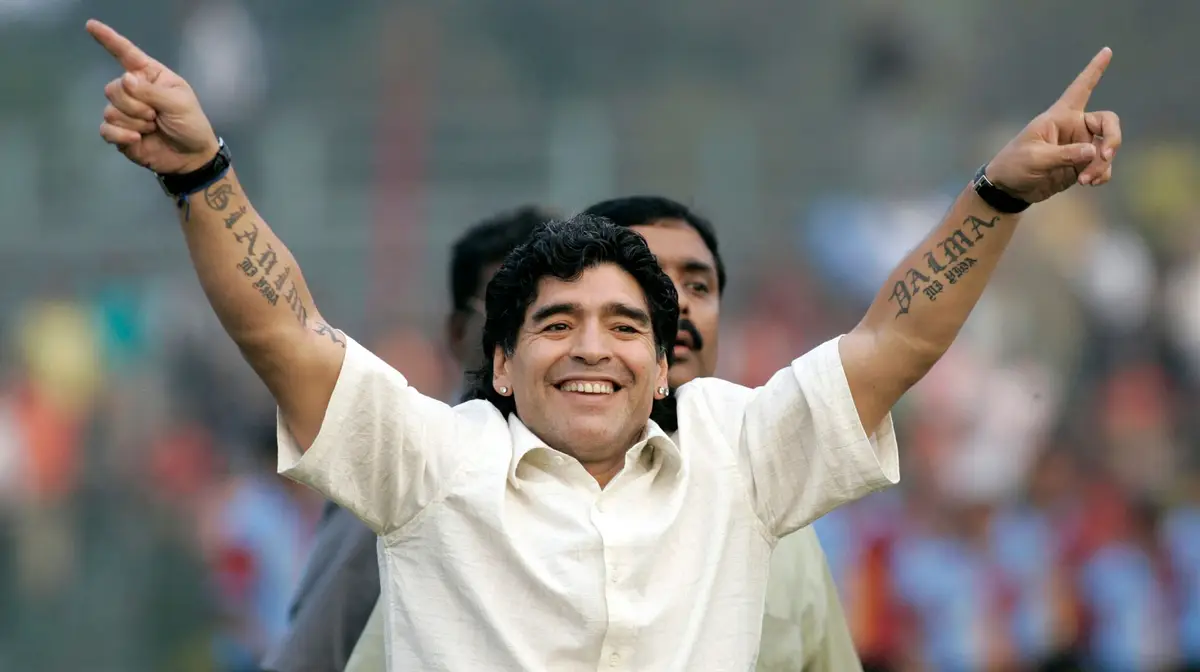 Diego Maradona showing Dalma and Gianinna lettering on his forearms