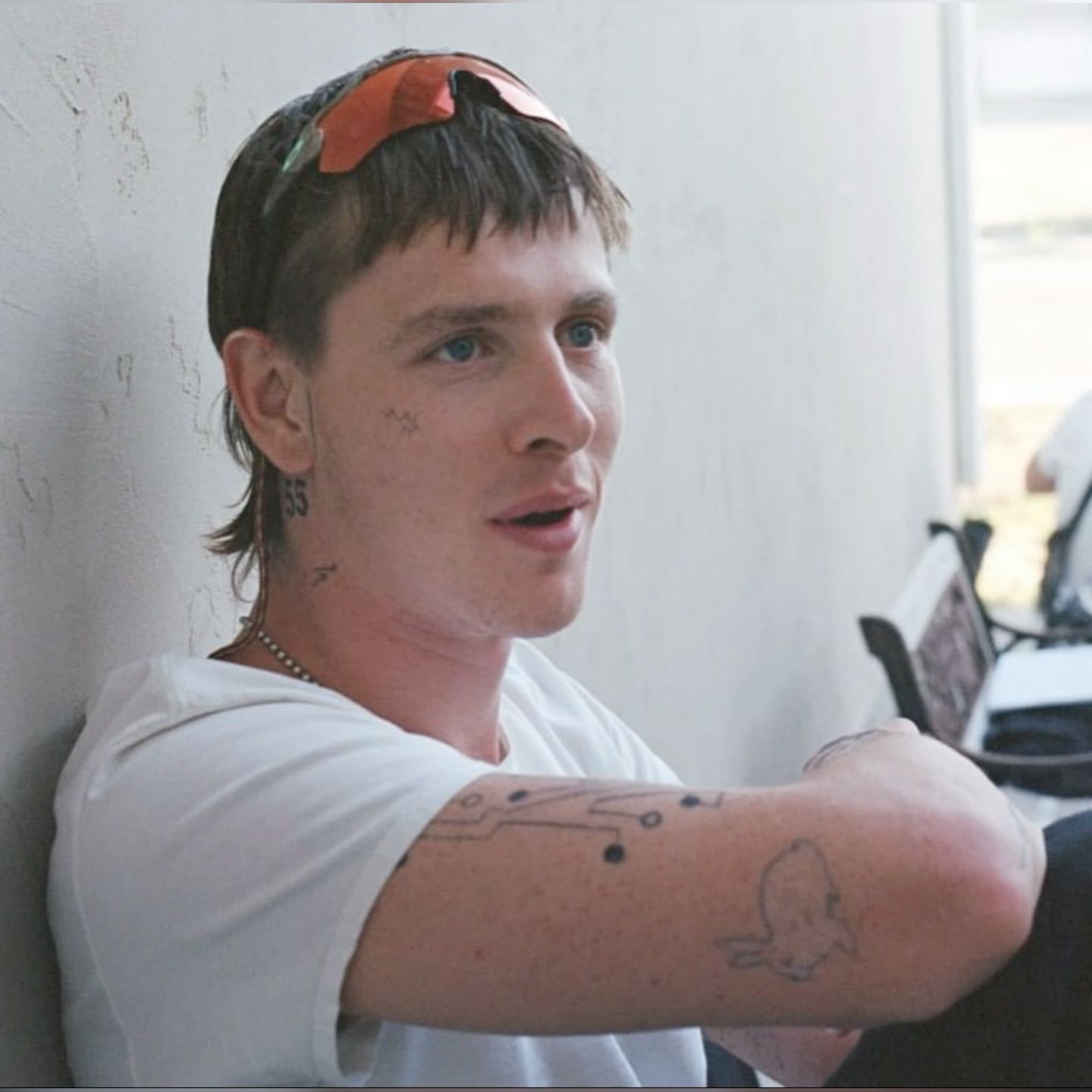 Harris Dickinson tattoos: Harris Dickinson forearm lettering and small neck symbols