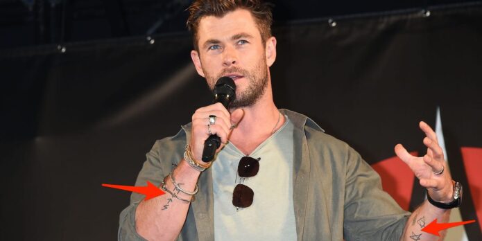 Chris Hemsworth on stage with arm tattoos visible