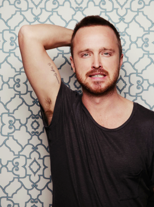 Aaron Paul showing his No Half Measures tattoo