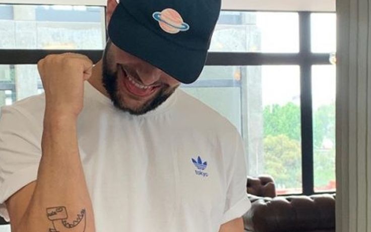 Finn Bálor shows the dinosaur tattoo on his elbow