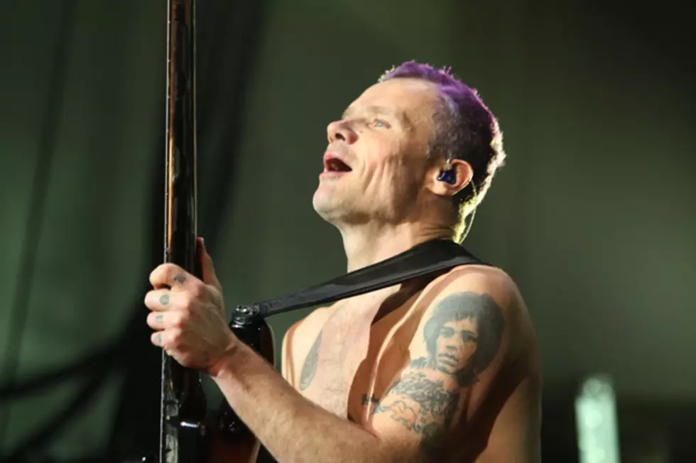 Flea showing the Jimi Hendrix portrait tattoo on his left upper arm