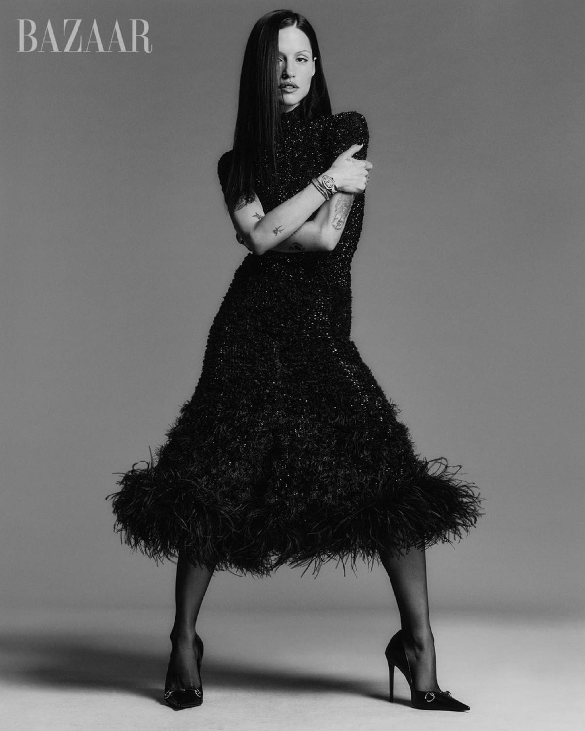 Gabbriette Bechtel showing arm and hand tattoos in a feathered dress