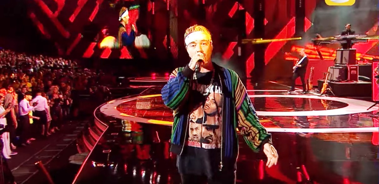 J Balvin showing the tiger, Mickey skull and Nirvana tattoo area