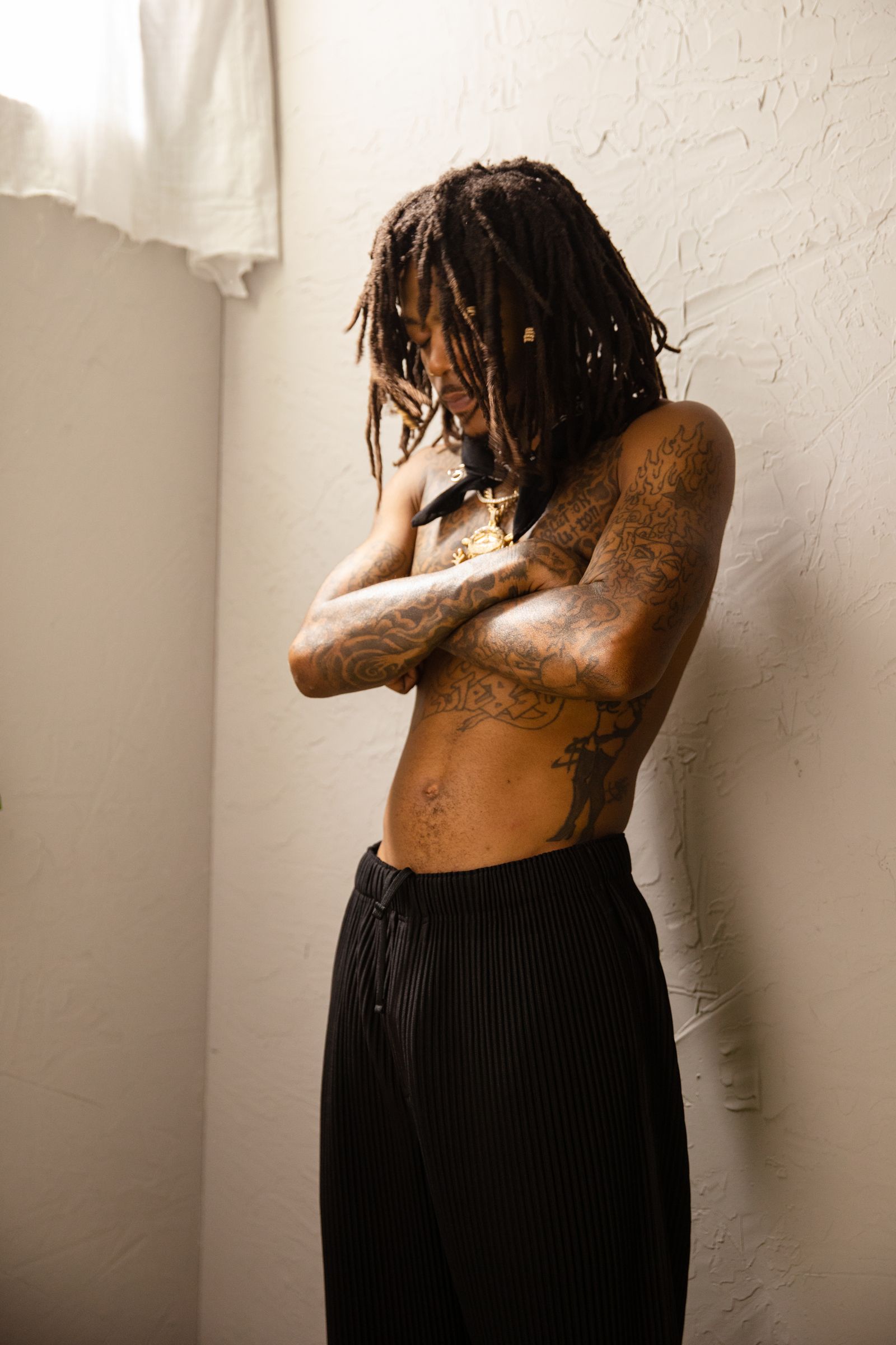 J.I.D in a GQ portrait with the lower-stomach and chest tattoos visible