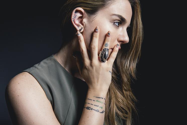JoJo showing the small music-related tattoo on her hand and her wrist tattoos