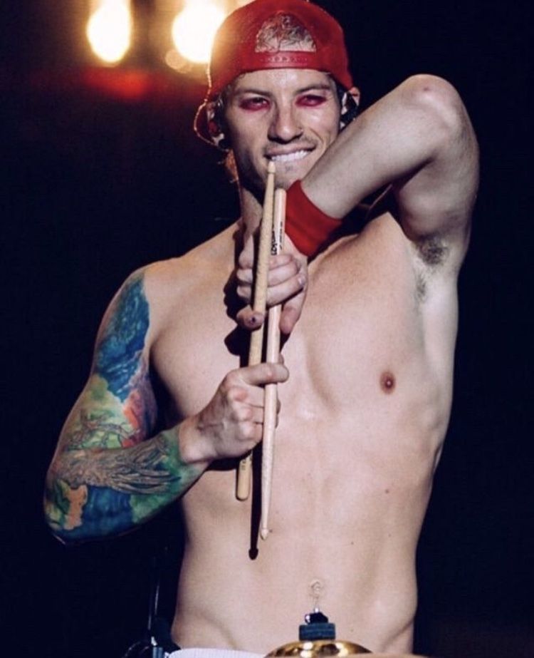 Josh Dun showing his sleeve tattoos while performing