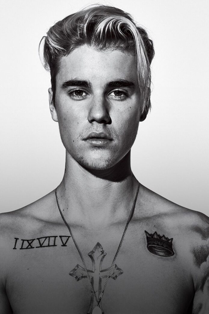 Justin Bieber showing Roman numerals and chest tattoos