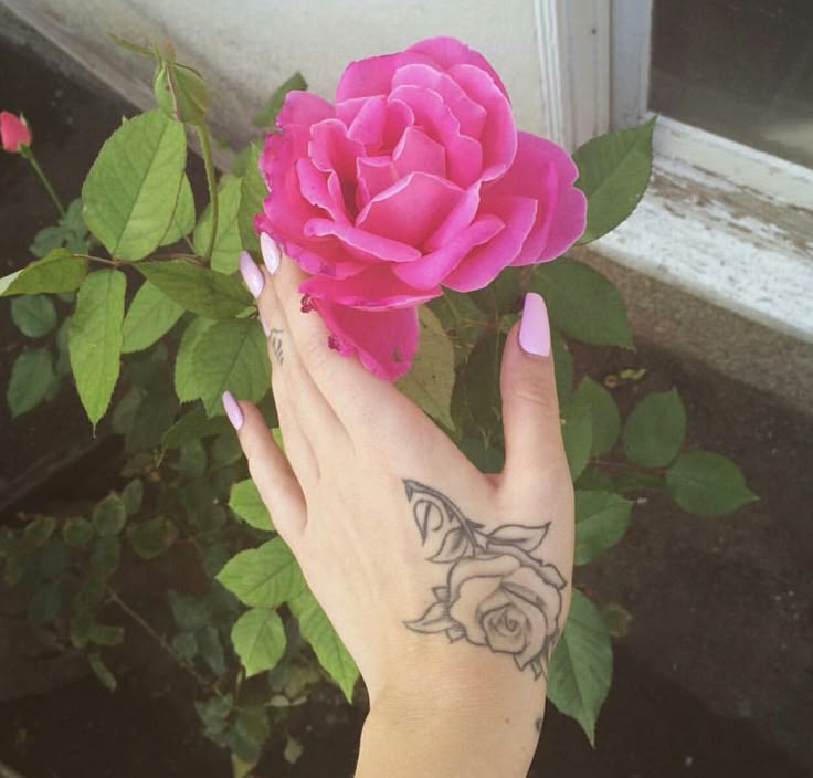 Kali Uchis Om symbol tattoo on her knuckle