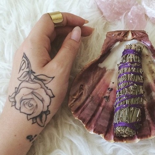 Kali Uchis rose tattoo on the back of her hand