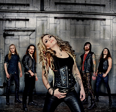 Kobra Paige forearm tattoos in a band photo