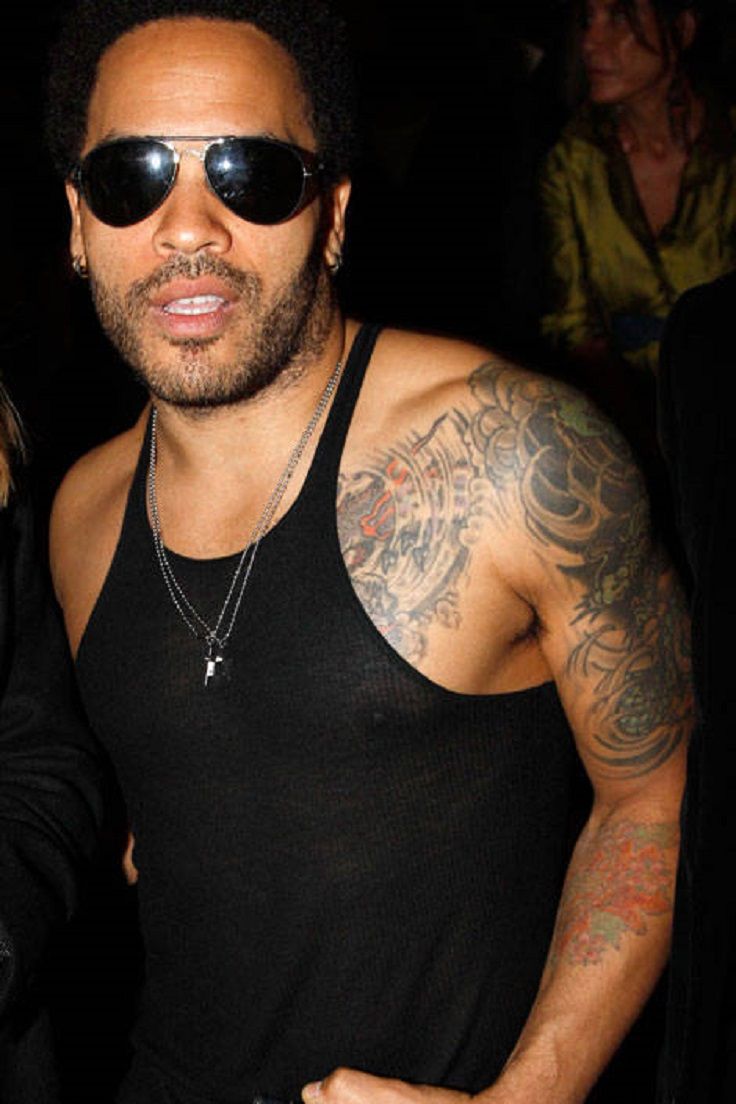 Lenny Kravitz upper-arm tattoo detail associated with the arrow-cross design