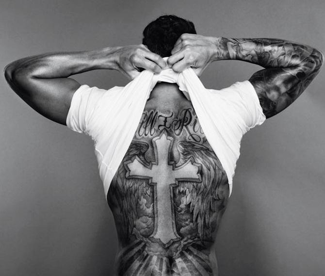 Lewis Hamilton showing the Still I Rise cross and wings back tattoo