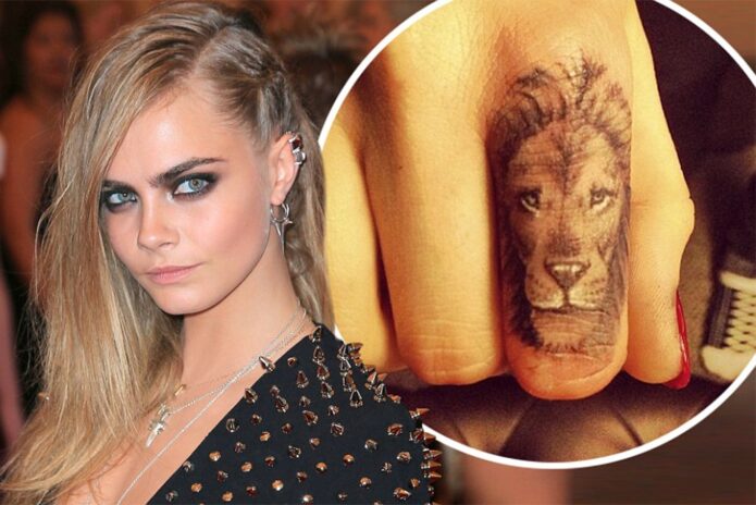 Cara Delevingne with a close view of her lion finger tattoo