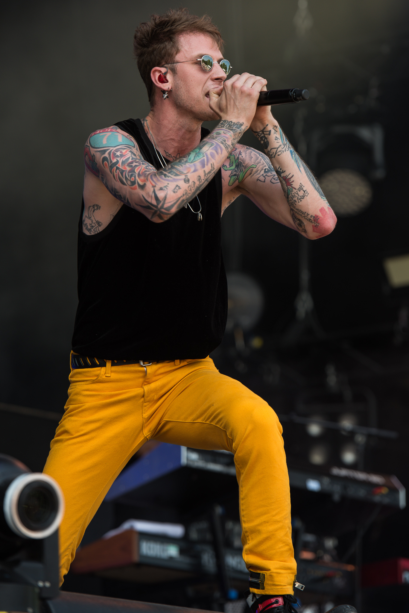 Machine Gun Kelly performing in 2017 with several pre-blackout tattoos visible across both arms
