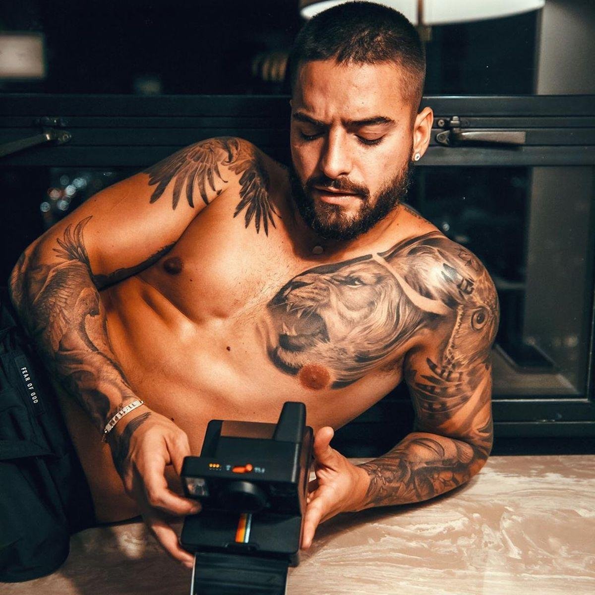Maluma showing the lion tattoo on his chest