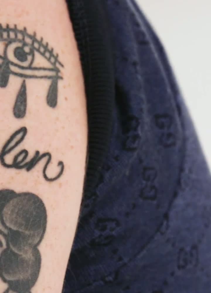Macklemore’s flower tattoo with the MAMA banner, shown in GQ’s Tattoo Tour.