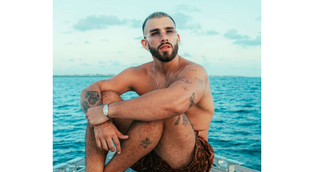 Manuel Turizo tattoos in an open-shirt seaside portrait
