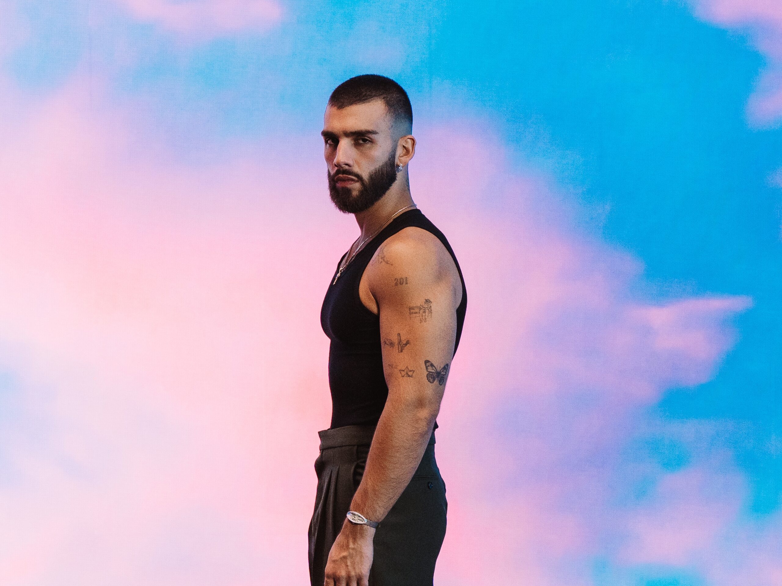 Manuel Turizo upper arm tattoos in an open-shirt portrait