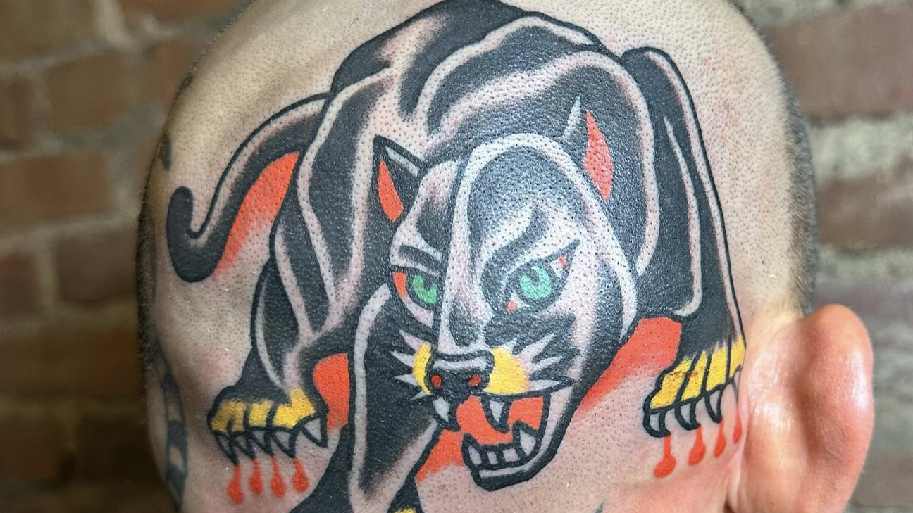 Marlon Vera black panther head tattoo with green eyes and yellow claws