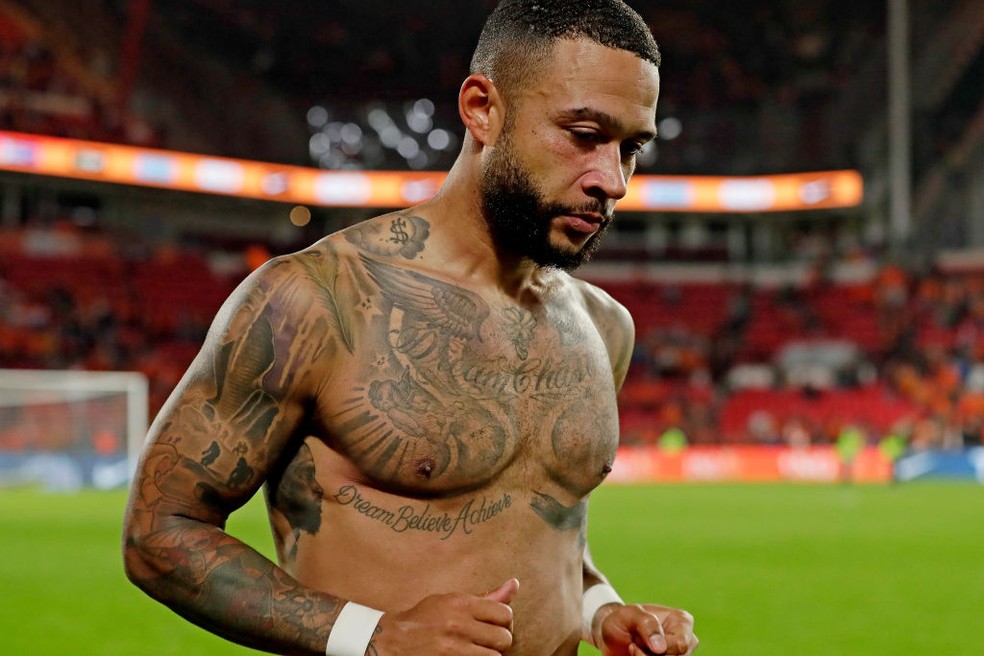 Memphis Depay Dream Believe Achieve tattoo across chest and stomach