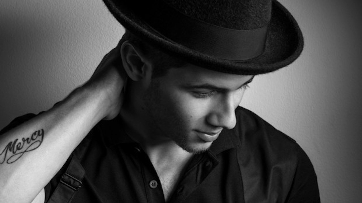 Nick Jonas showing Mercy lettering on his forearm