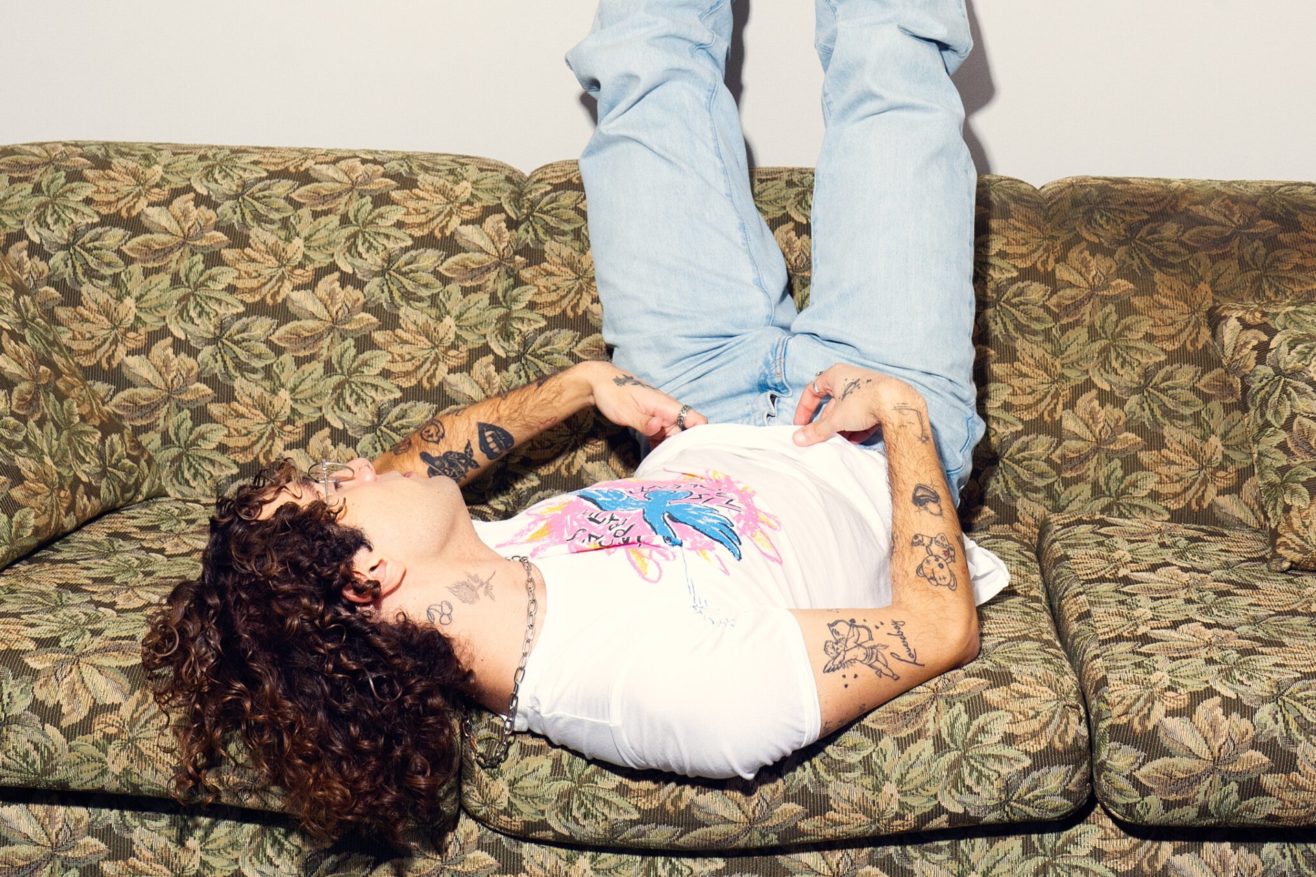 Nicolas McCoppin reclining portrait showing both arm tattoos