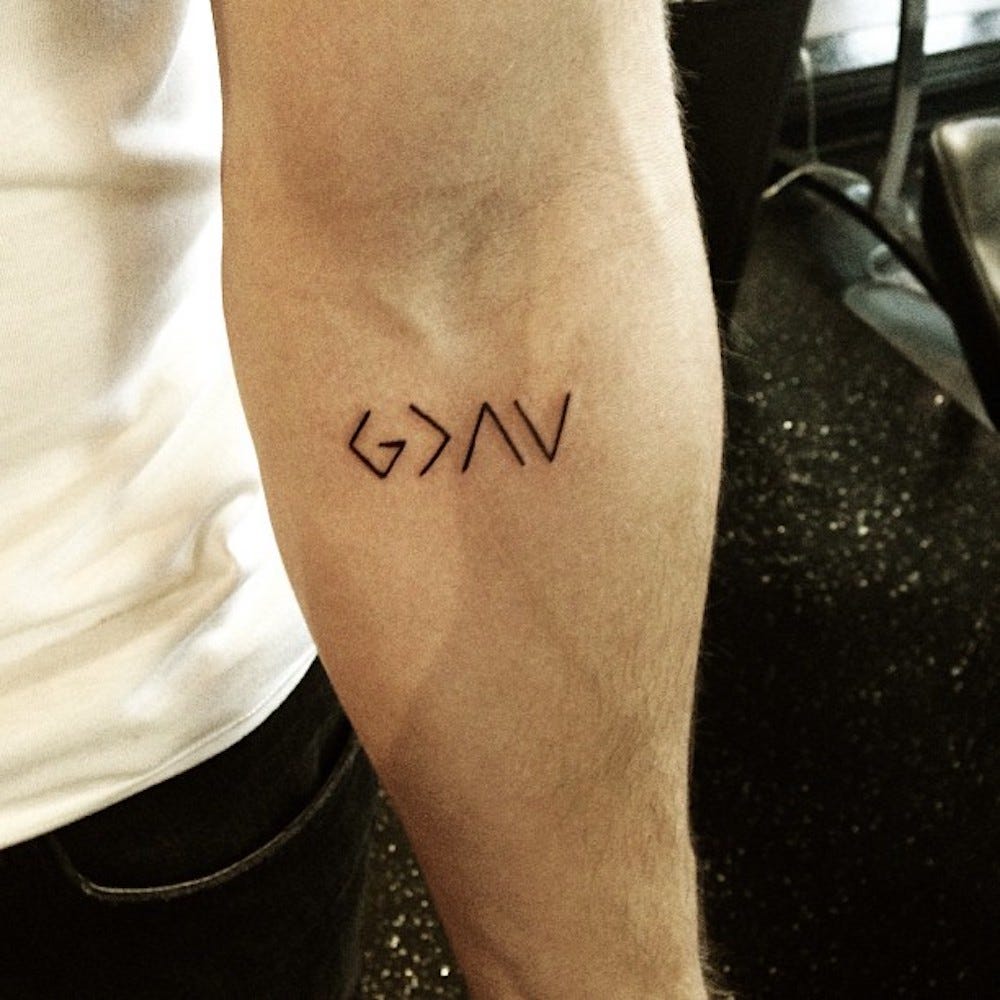 Nick Jonas’s geometric G, greater-than sign, peak and valley tattoo on his inner forearm