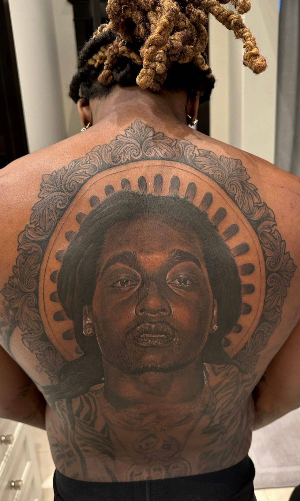 Offset’s Takeoff portrait tattoo across his back, shown in a vertical photograph.