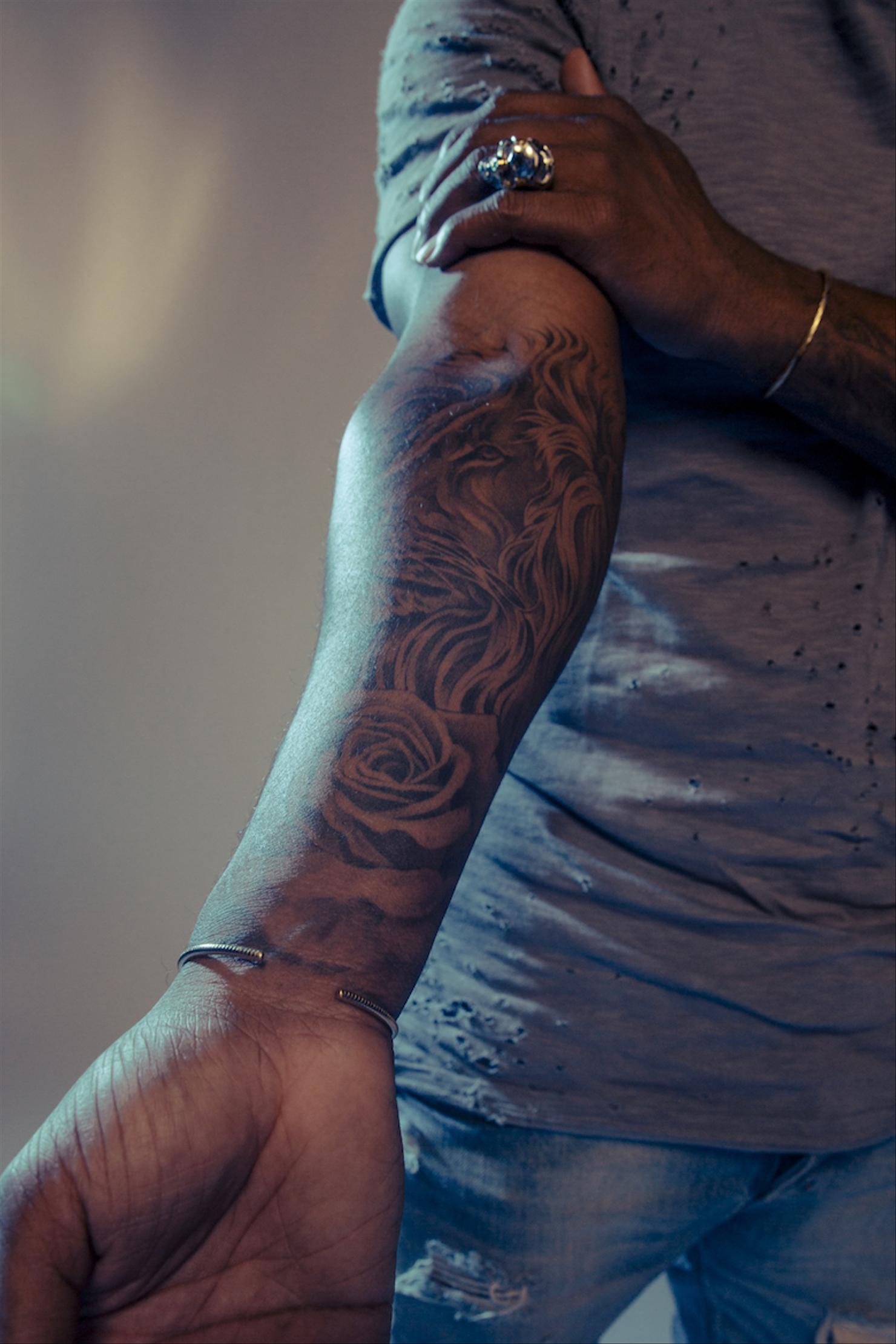 Omarion lion and rose forearm tattoo